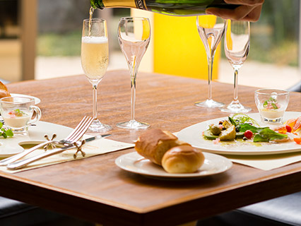 テーブルに並んだ料理とワインを注ぐ画像